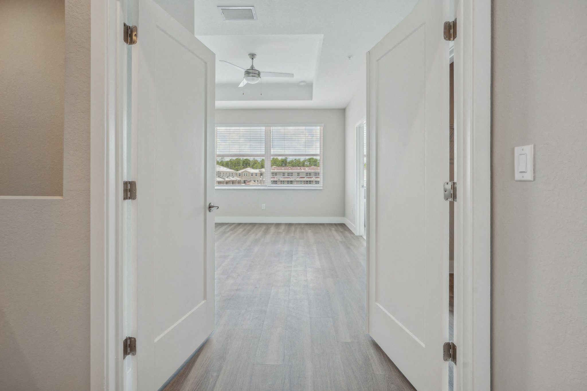 an empty living room with white walls and a window